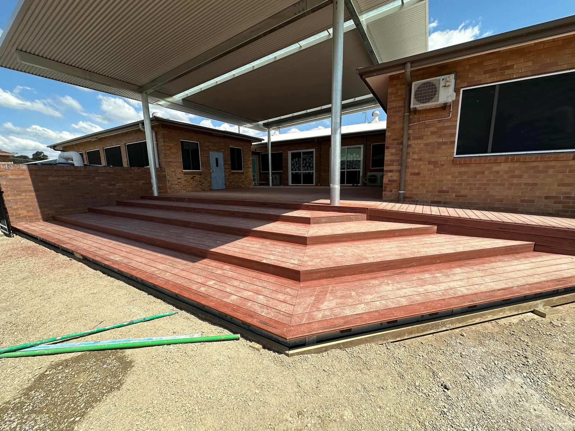 A Man Is Sitting on A Scaffolding on Top of A Wooden Structure — Highline Carpentry in Kahibah, NSW
