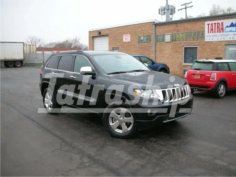 A black jeep is parked in front of a building that says tatra
