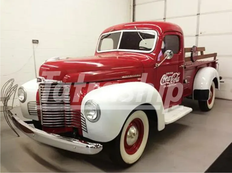 A red coca cola truck is parked in a garage