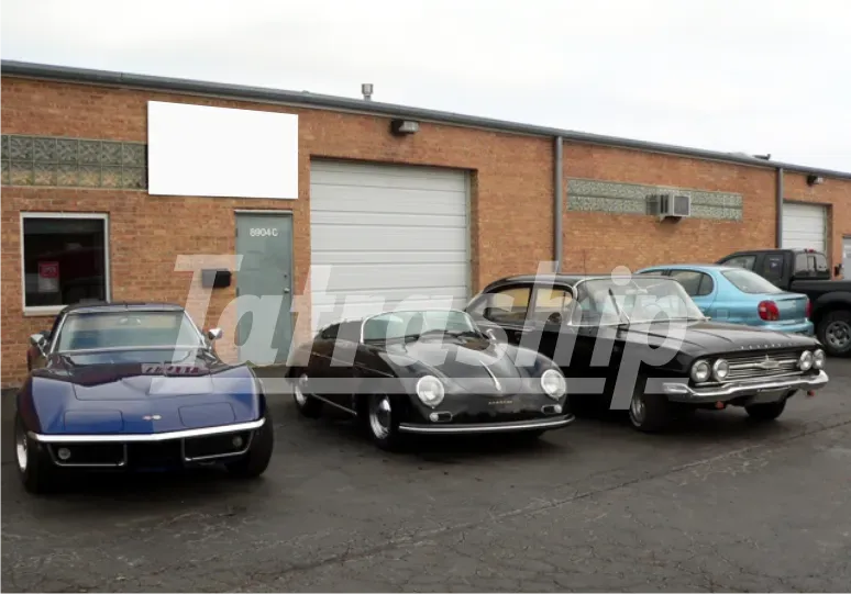 Three cars are parked in front of a brick building