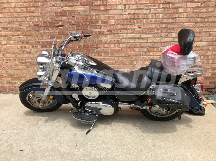 A motorcycle is parked in front of a brick wall.
