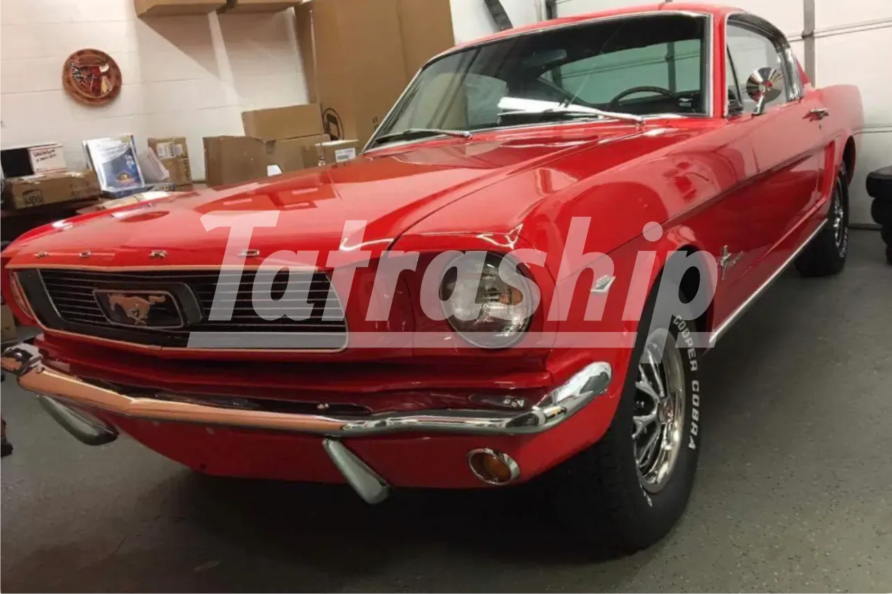 A red ford mustang is parked in a garage.