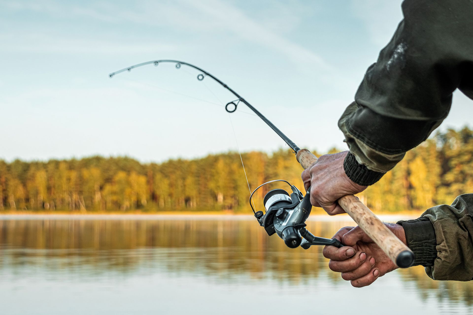 A man is fishing on a lake with a fishing rod.