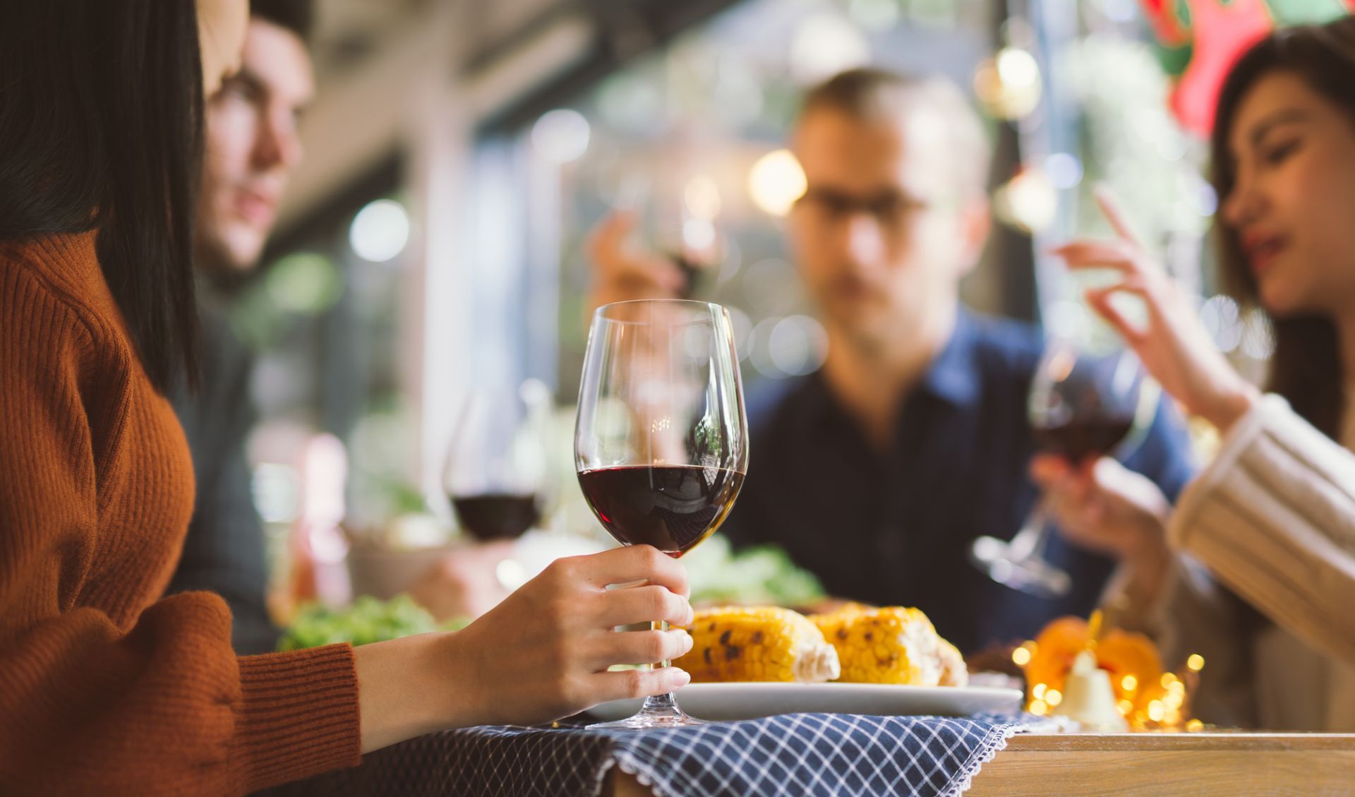 A group of people are sitting at a table drinking wine.