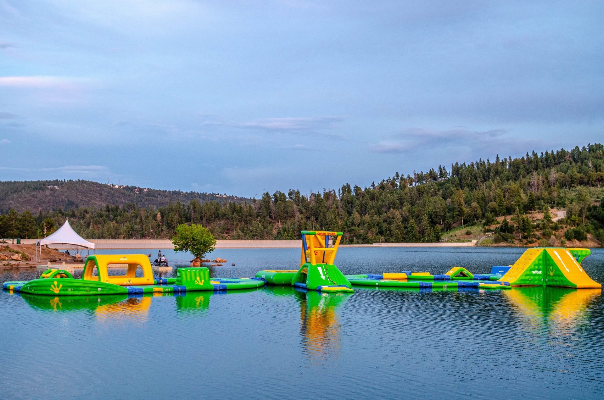 A large inflatable water park is floating on top of a lake.