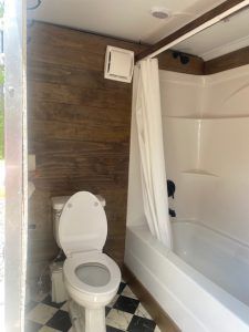 A bathroom with a toilet , tub and shower.