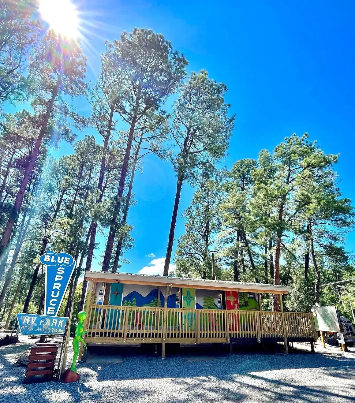 A small house in the middle of a forest with trees in the background.