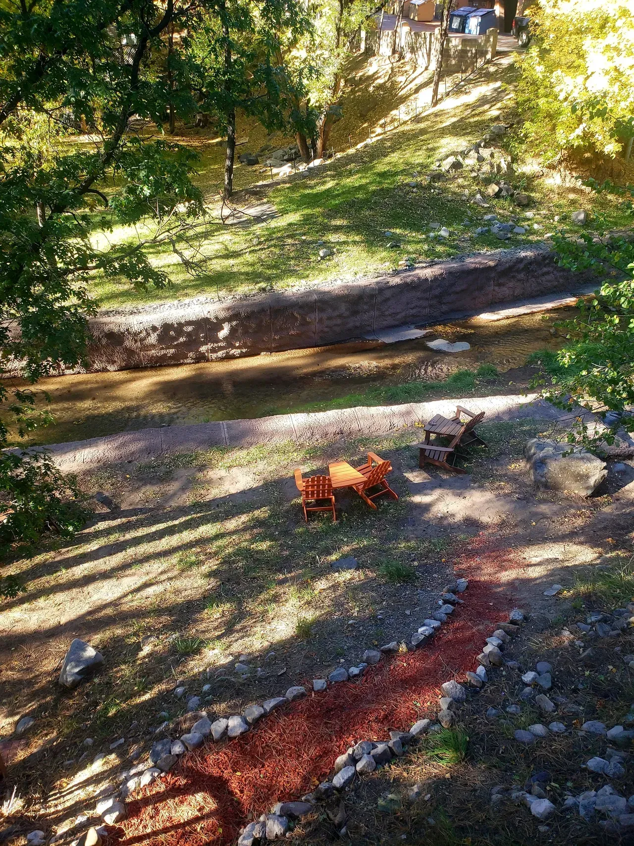 An aerial view of a park with a path and a fire pit