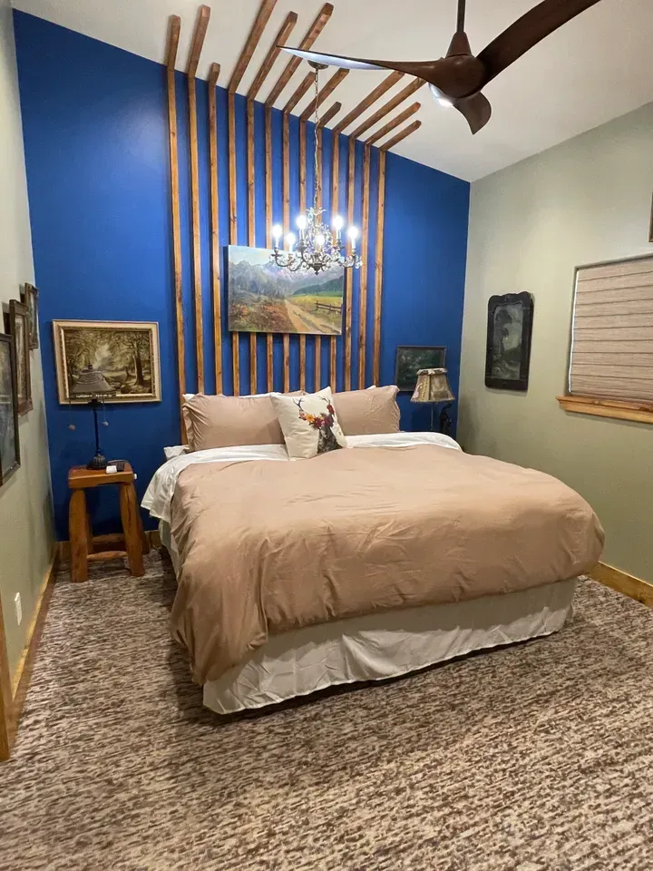A bedroom with a king size bed and a ceiling fan.