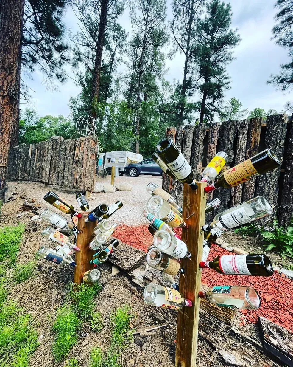 A bunch of wine bottles are sitting on top of a wooden post.