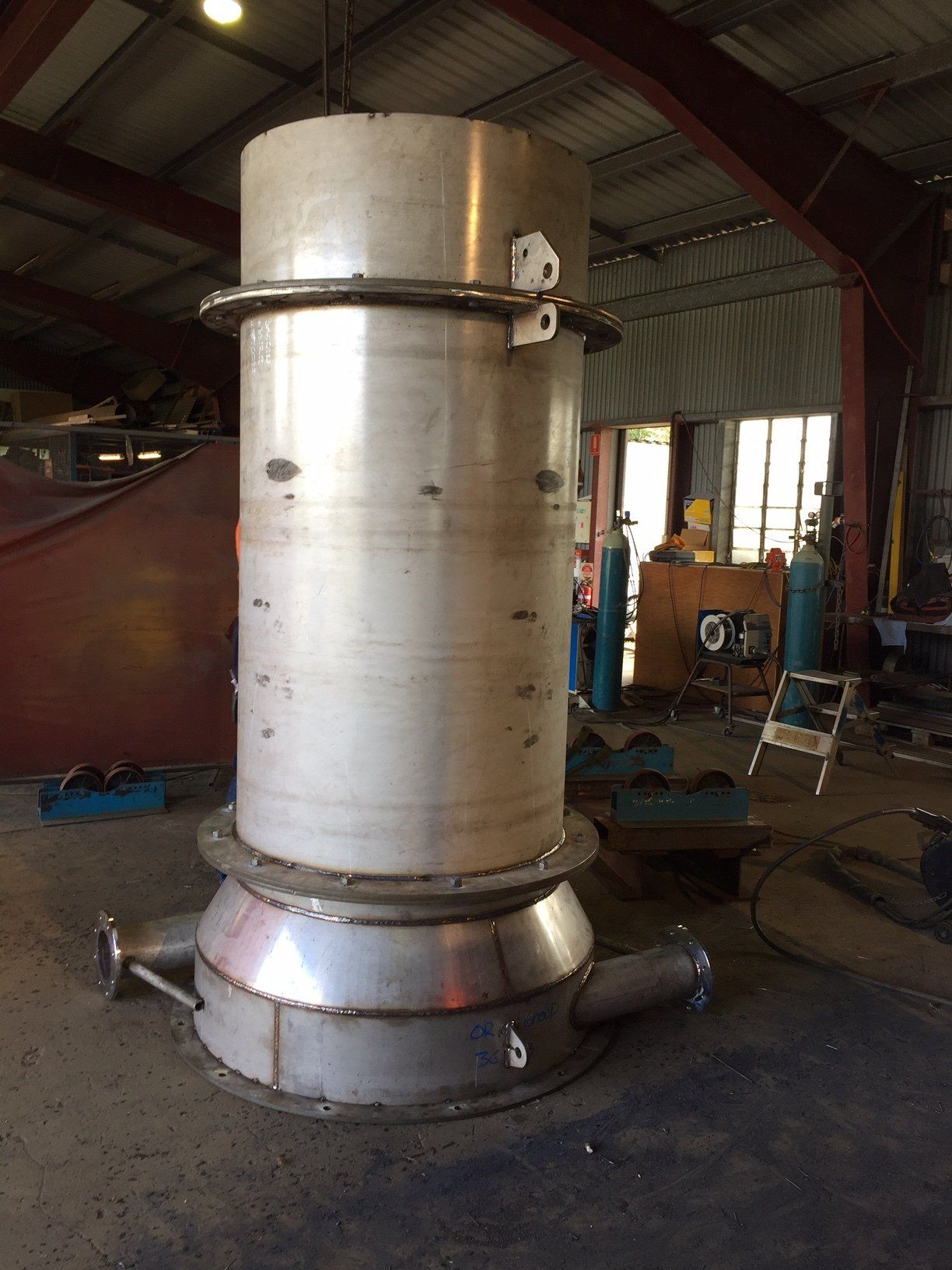 A Large Stainless Steel Cylinder Is Being Built In A Factory — Origin Group in Paget, QLD
