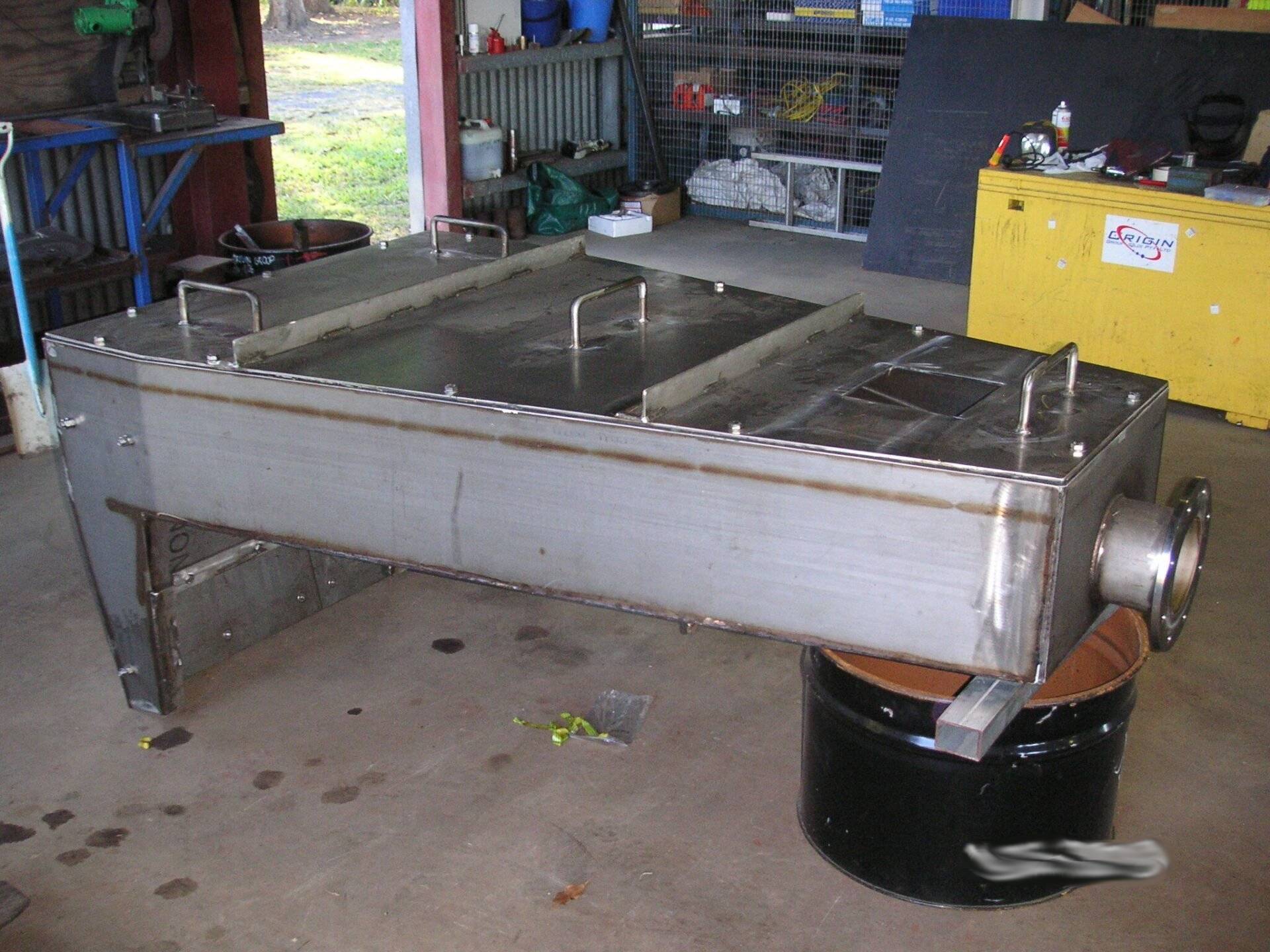 A Large Stainless Steel Container Is Sitting On Top Of A Black Barrel — Origin Group in Paget, QLD