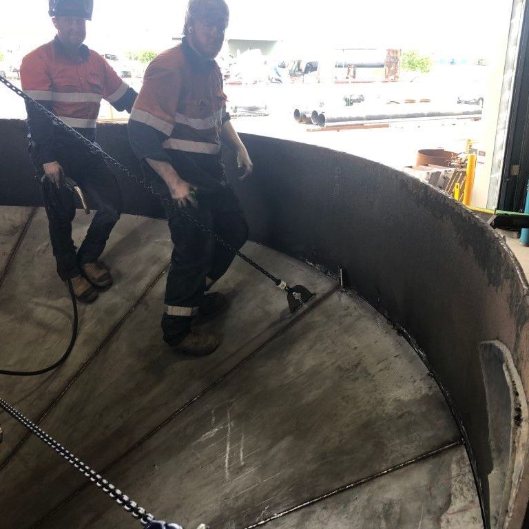 Workers Inspecting the Underside of a Tank Lid — Origin Group in Paget, QLD
