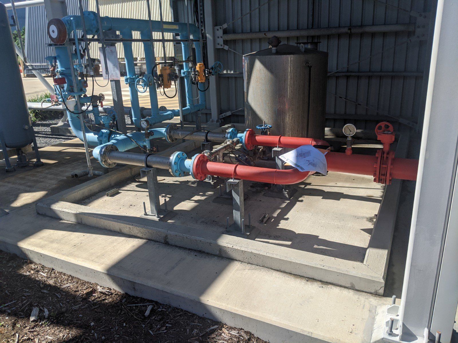A Bunch Of Pipes Are Sitting Outside Of A Building — Origin Group in Paget, QLD