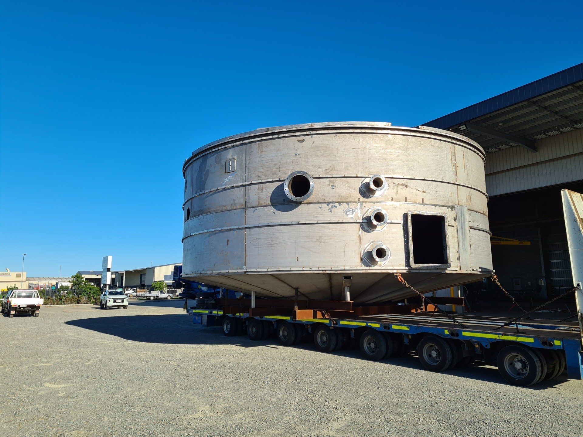 A Large Stainless Steel Tank Is Being Transported On A Trailer — Origin Group in Paget, QLD