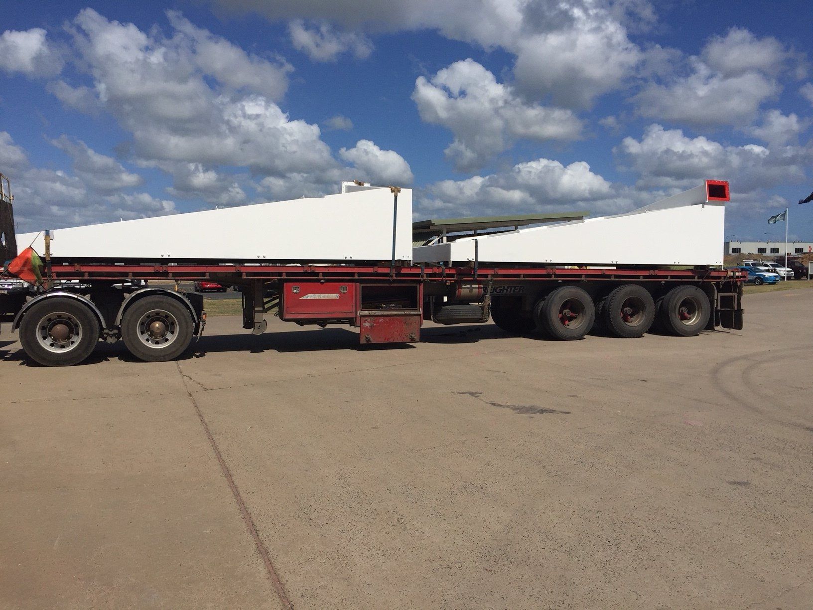 A Red And White Semi Truck Is Parked In A Parking Lot — Origin Group in Paget, QLD