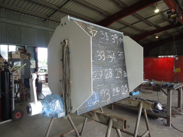 A Large Piece Of Metal Is Sitting On A Wooden Stand In A Warehouse — Origin Group in Paget, QLD