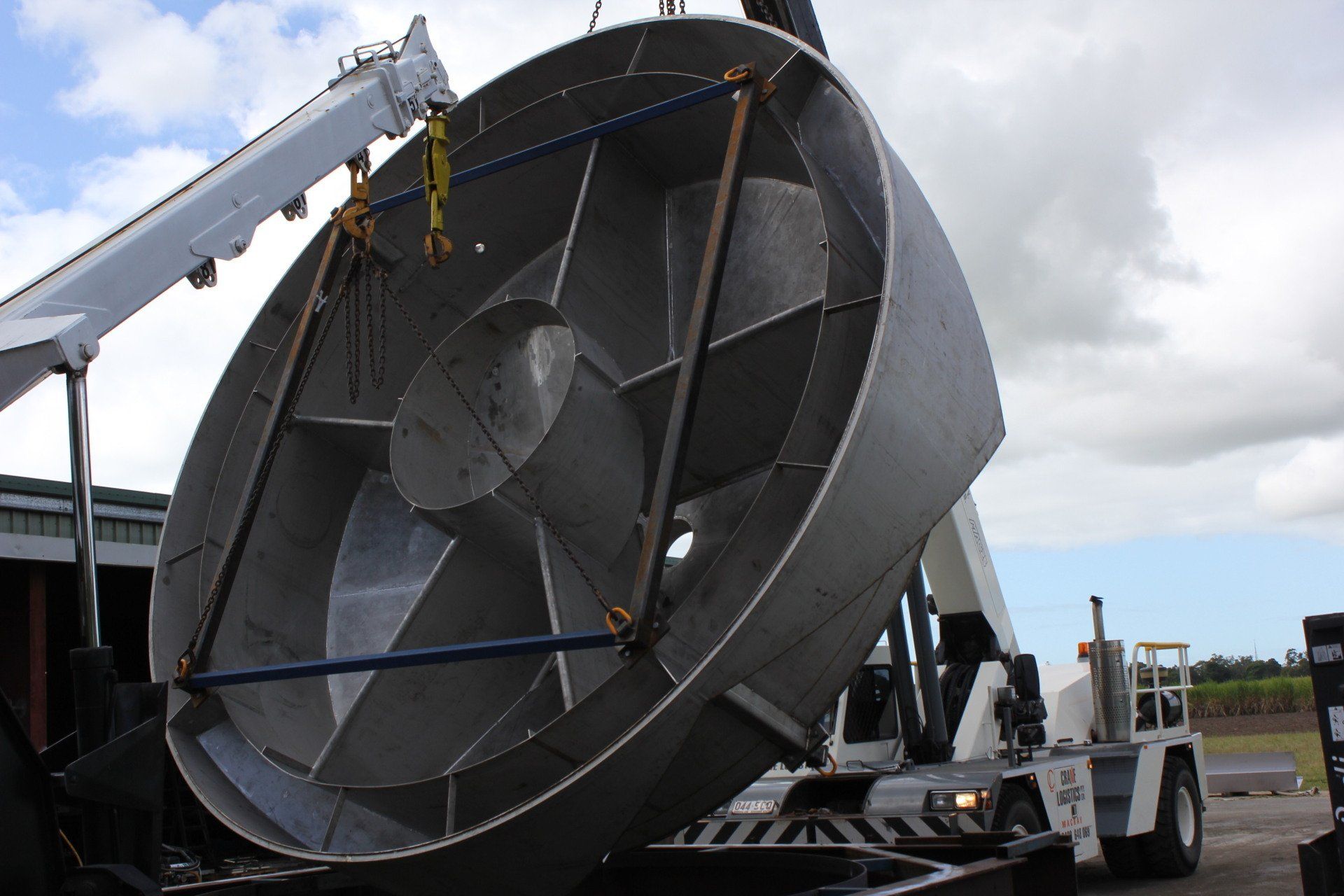 A Large Metal Fan Is Being Lifted By A Crane — Origin Group in Paget, QLD