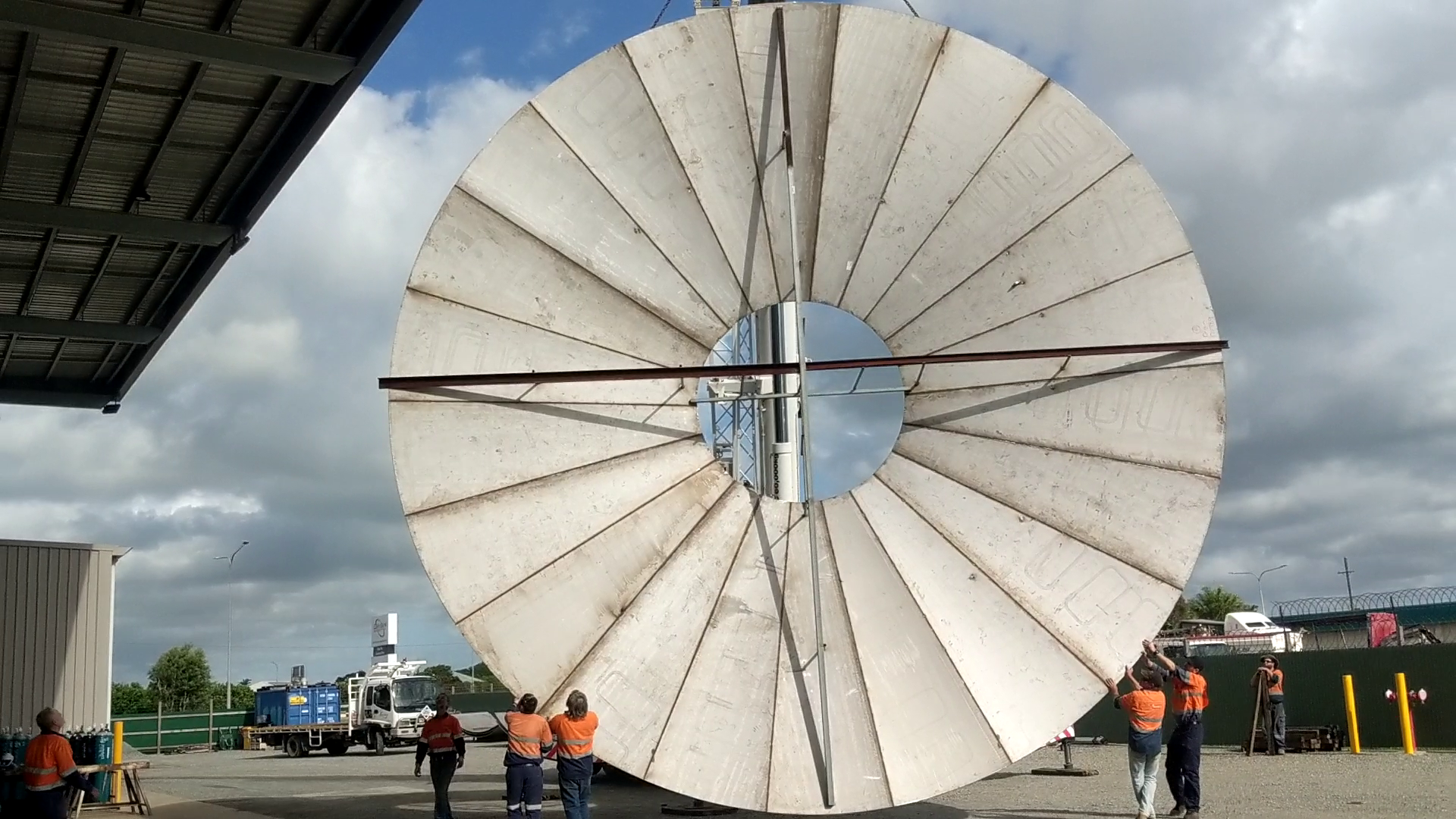 A Group Of People Standing Around A Large White Circular Object — Origin Group in Paget, QLD