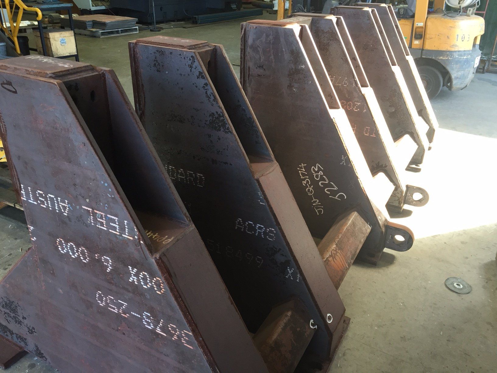 A Yellow Forklift Is Parked Behind A Row Of Rusty Metal Pieces — Origin Group in Paget, QLD