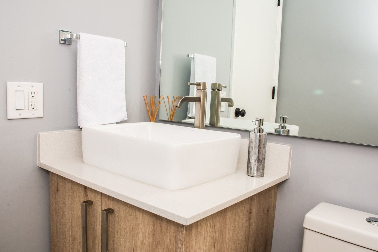 A bathroom with a sink , toilet and mirror.