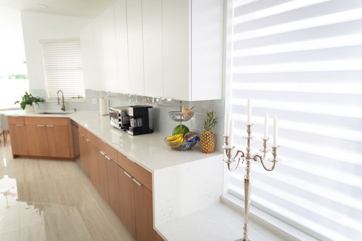 A kitchen with a candle holder and a bowl of fruit on the counter.