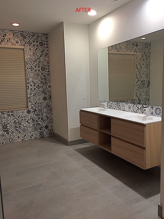 A bathroom with two sinks and a large mirror.