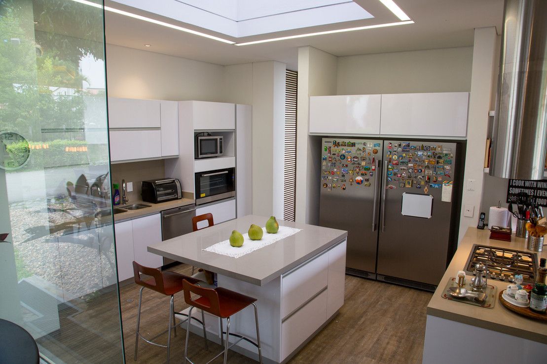 A kitchen with a large island in the middle and a refrigerator.