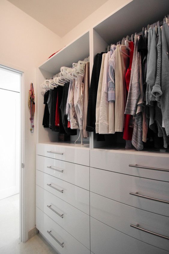 A walk in closet filled with clothes and drawers