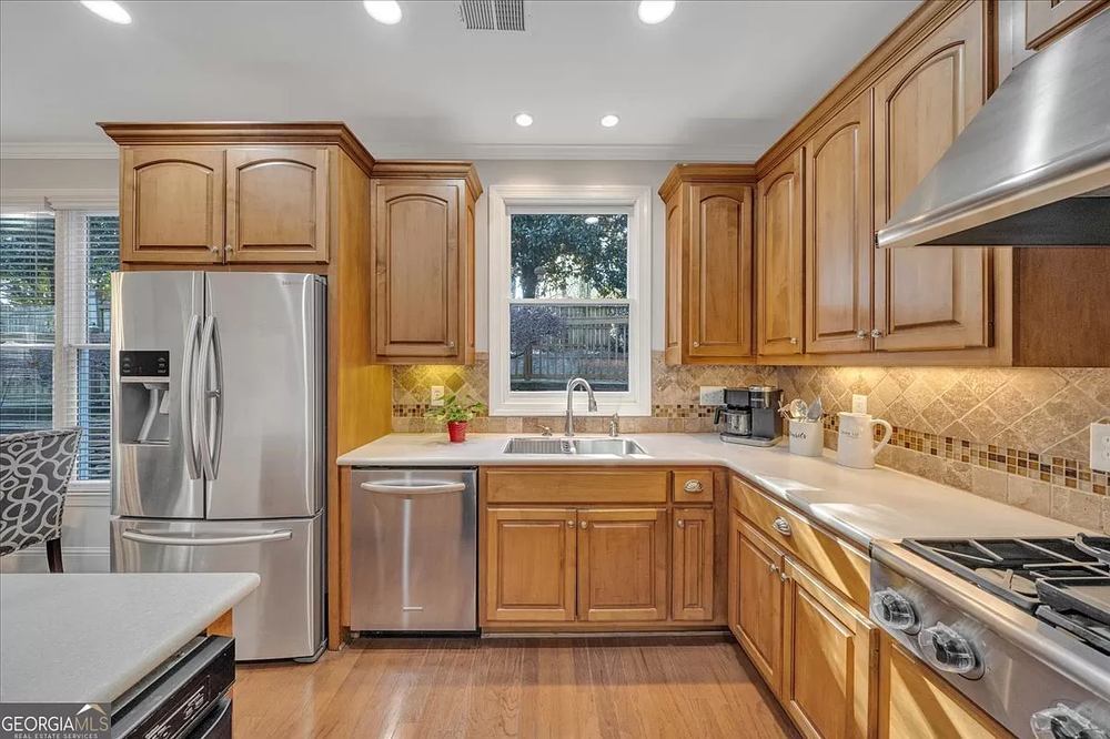 A kitchen with stainless steel appliances and wooden cabinets.