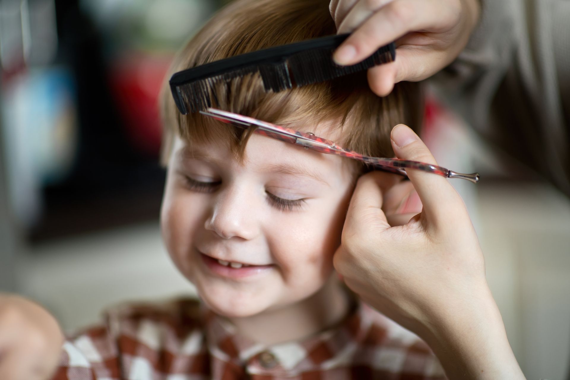 A little boy is getting his haircut