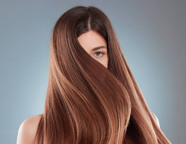 A woman with long brown hair covering half of her face