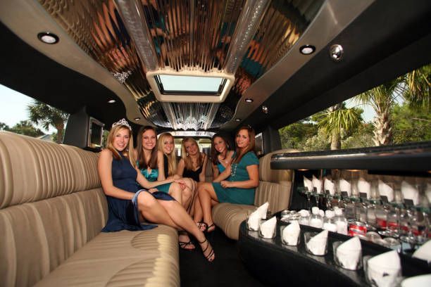 A group of women is enjoying a luxurious limo ride, dressed elegantly for a prom night celebration.