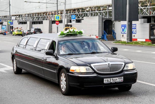 A black limousine parked in front of a building, indicating a limo rental service.