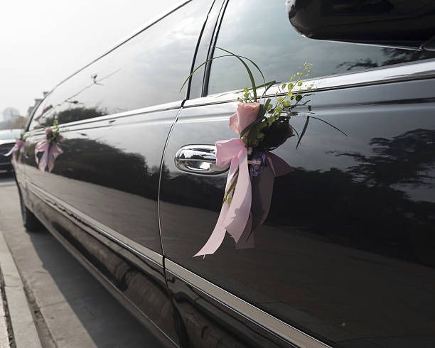  A luxurious limousine featuring a decorative flower on the door, perfect for wedding transportation