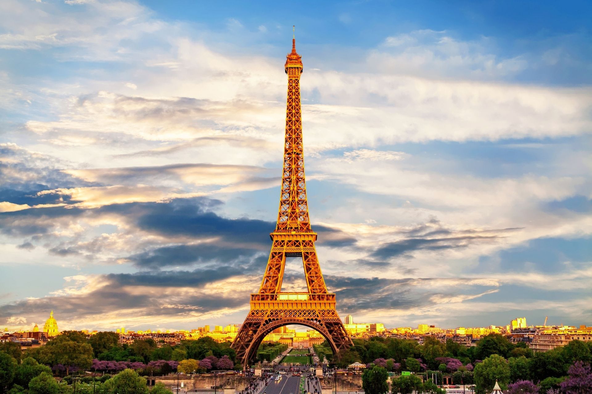 The eiffel tower is lit up at sunset in paris.