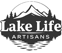 A black and white logo for lake life artisans with mountains and trees.