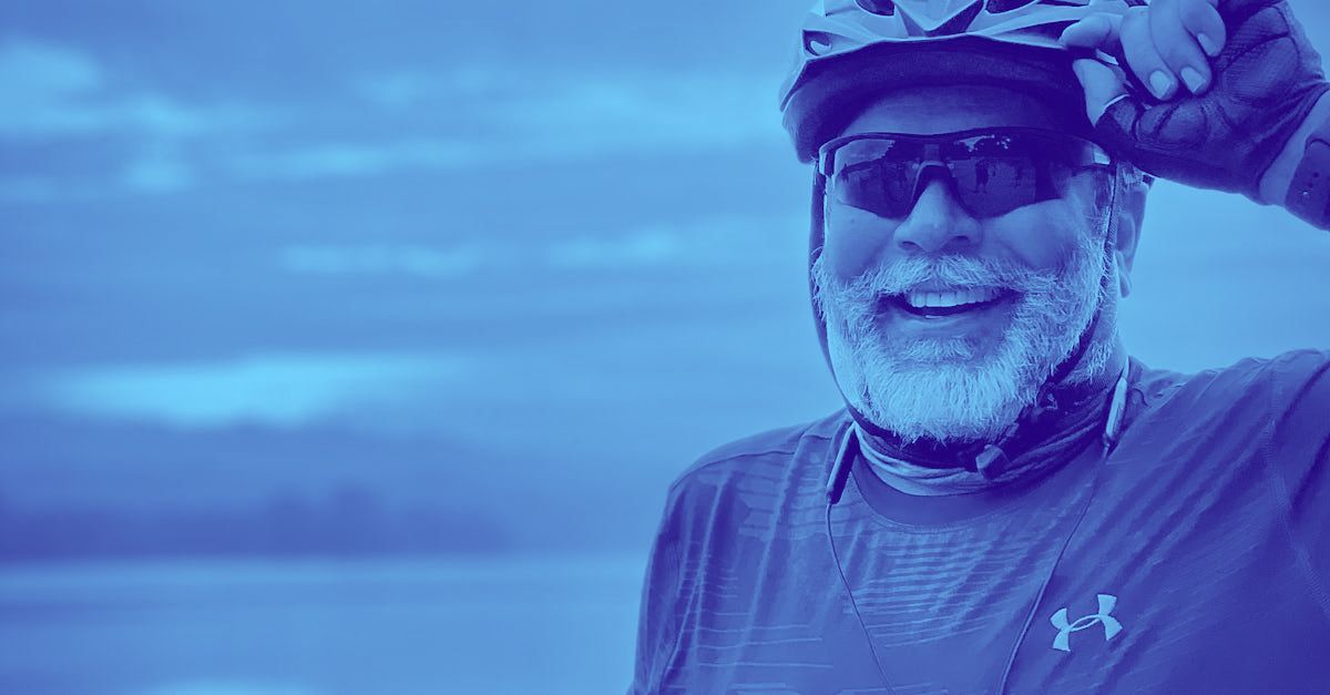 A man with a beard is wearing a helmet and sunglasses.