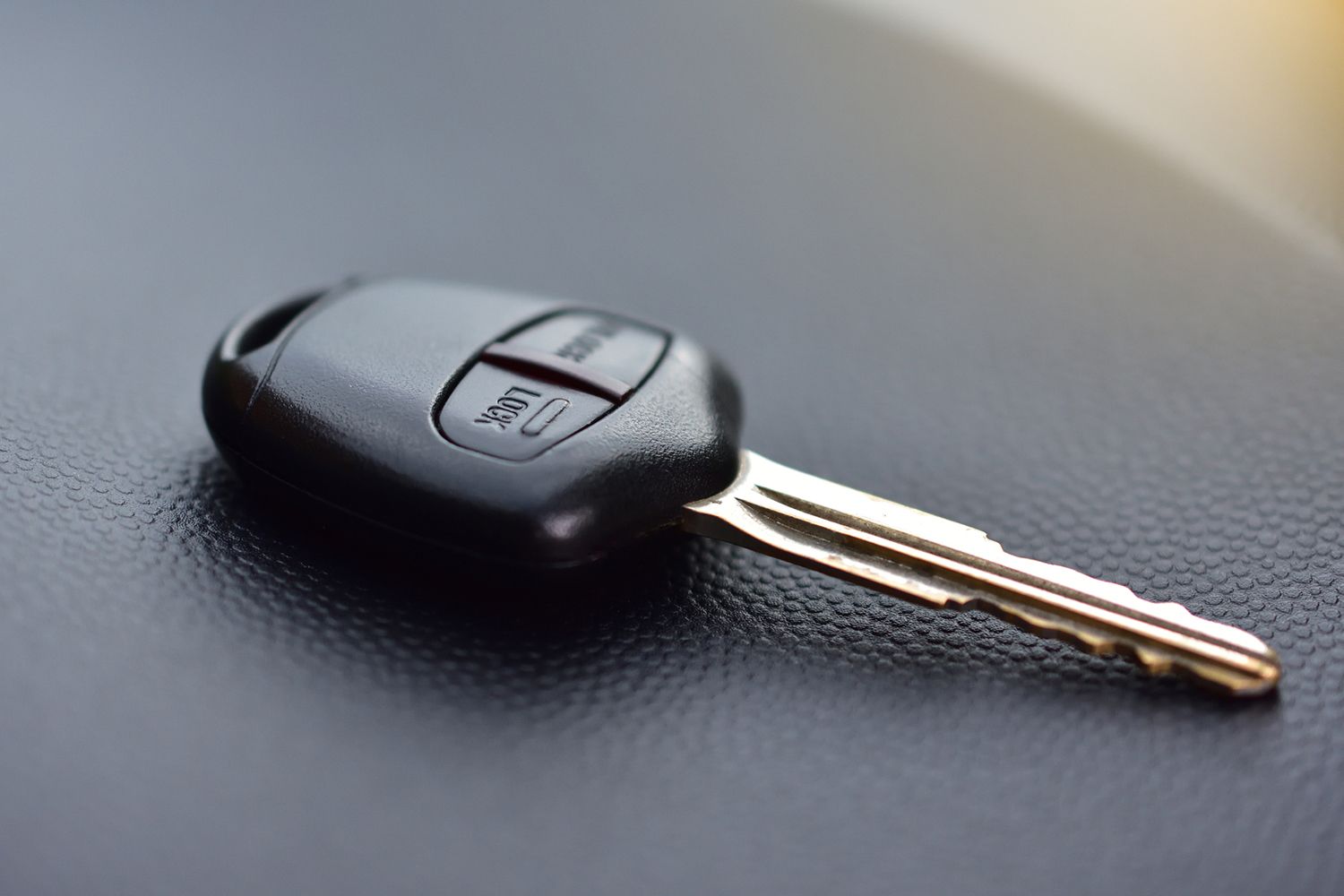 A close up of a car key on a black surface.