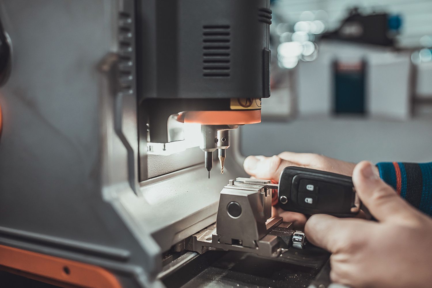 A person is using a machine to make a car key.