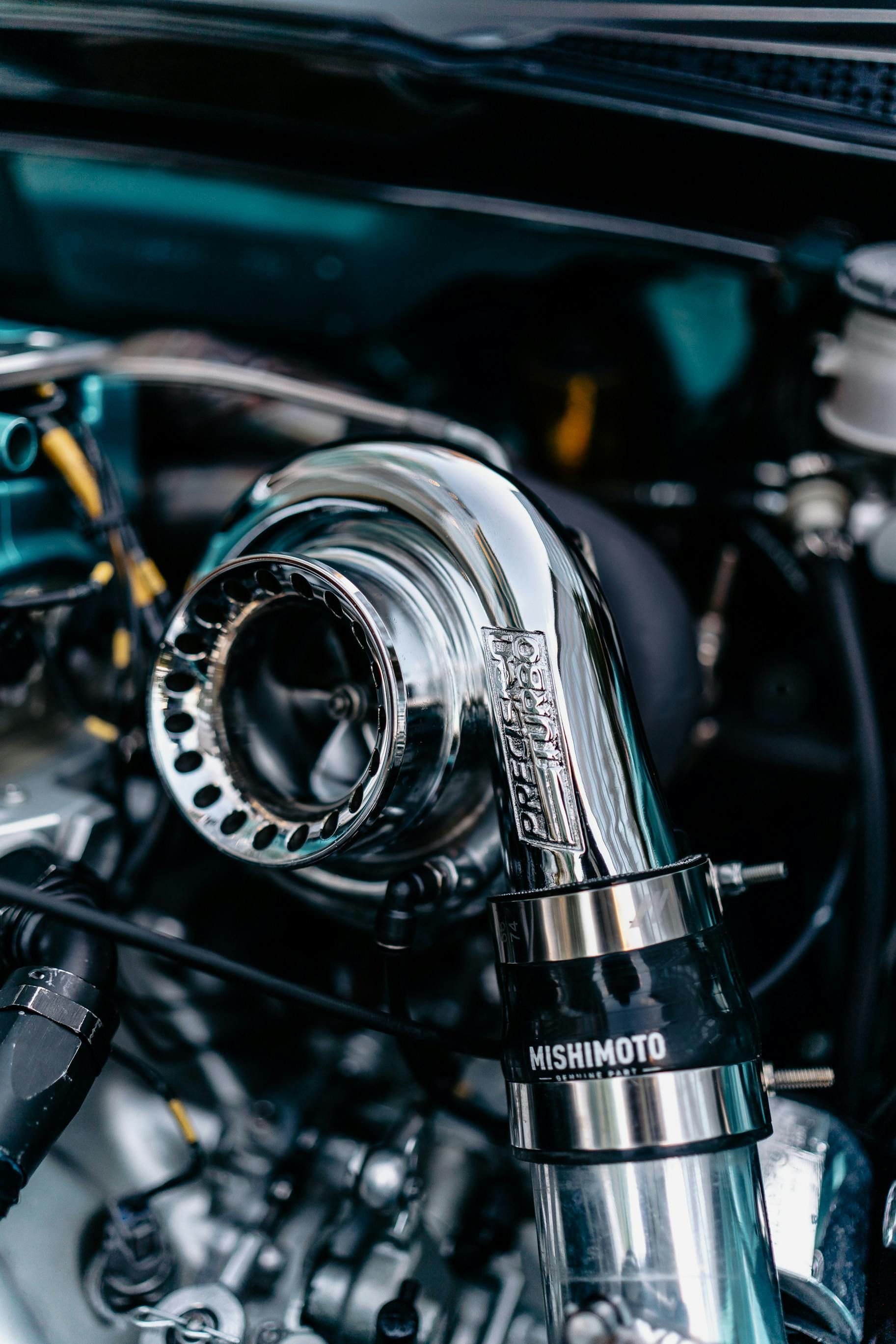 A close up of a turbocharger on a car engine.