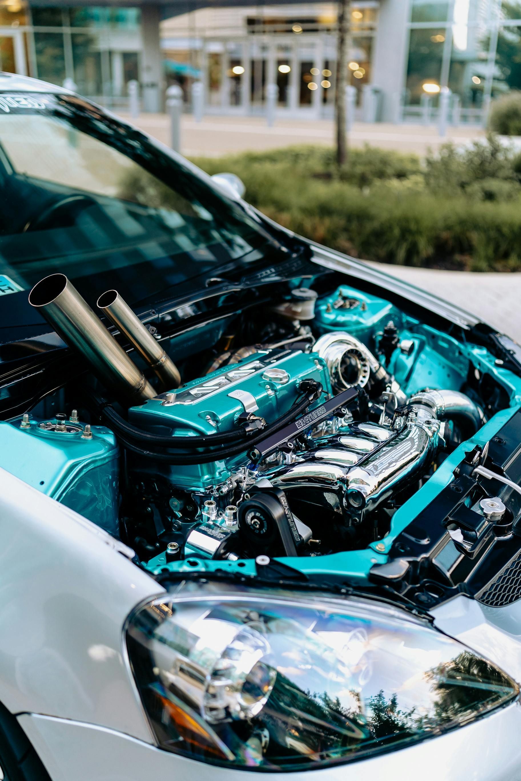 The engine of a car is visible under the hood.