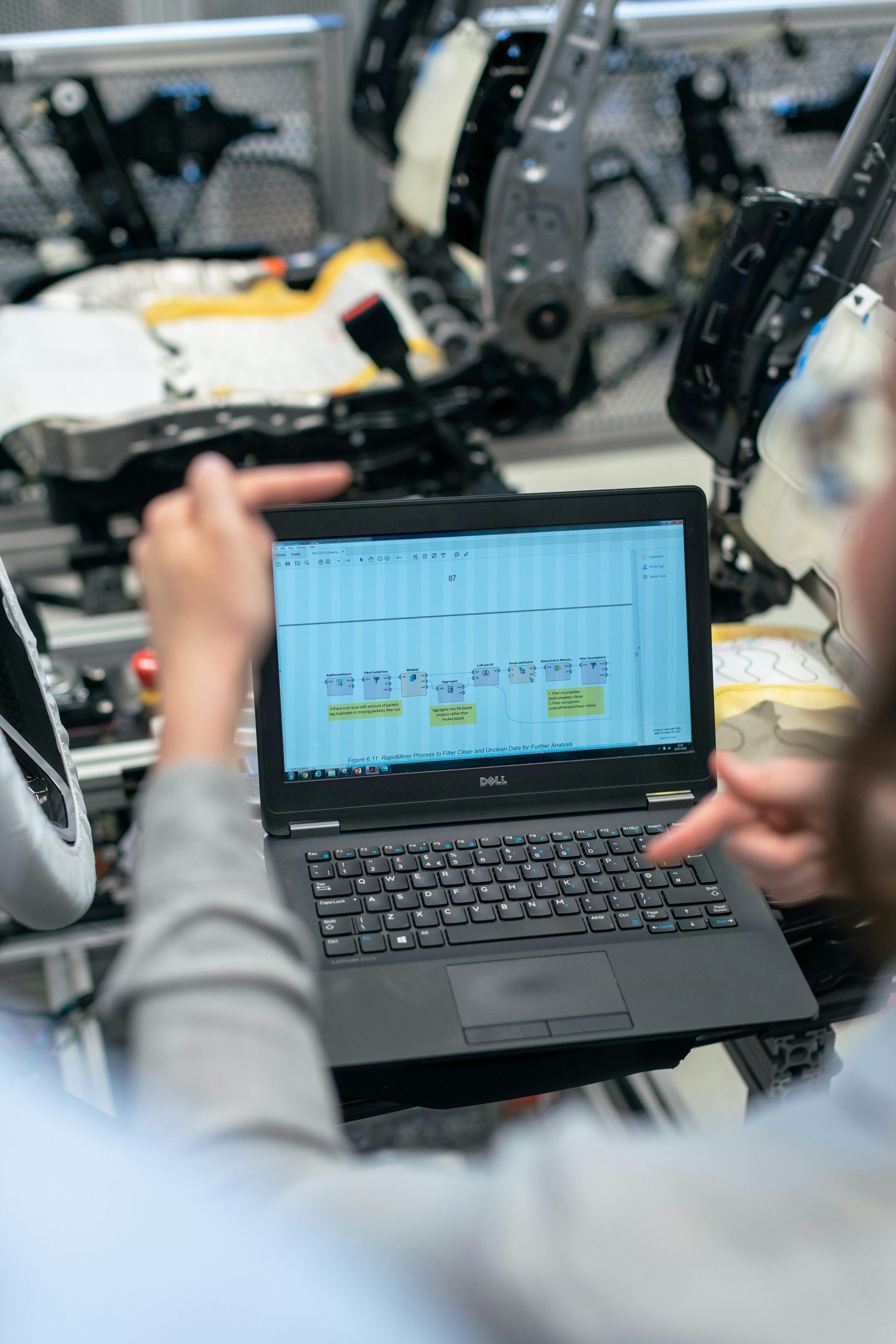 A person is using a laptop computer in a factory.