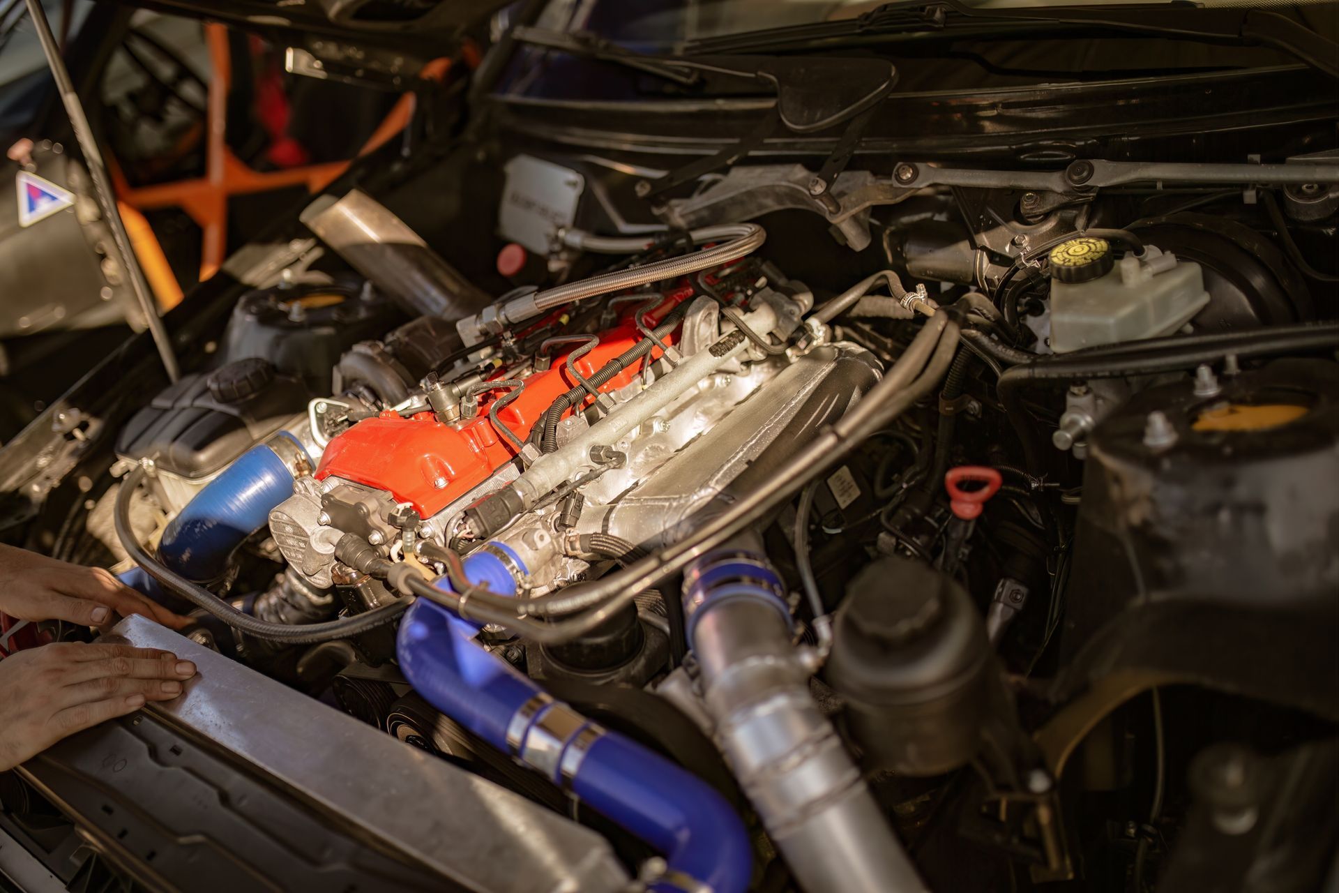 A person is working on the engine of a car.