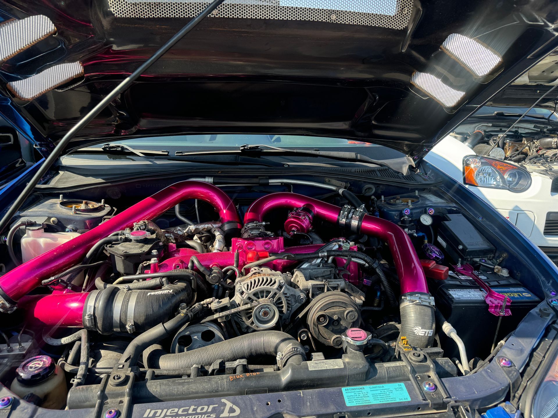 A close up of a car engine with the hood open.