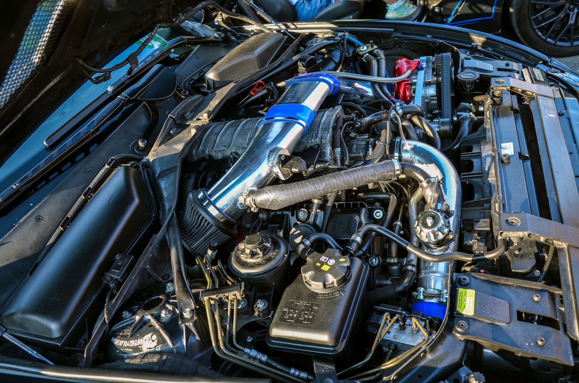 A close up of the engine of a car with the hood open.