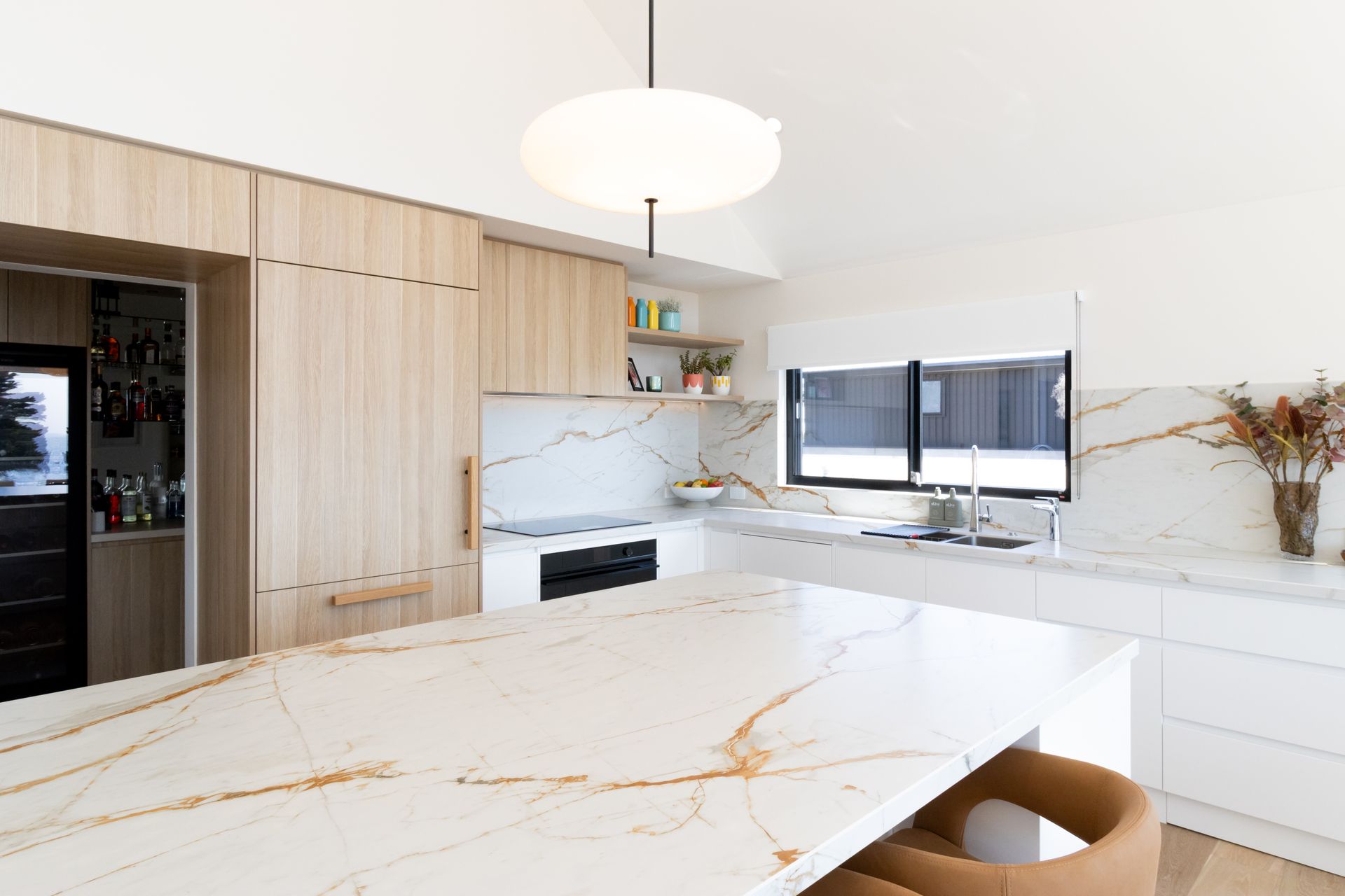 A kitchen with a large island and a marble counter top.