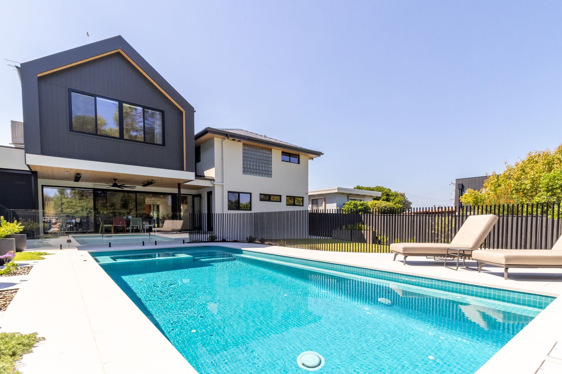 A large house with a swimming pool in front of it