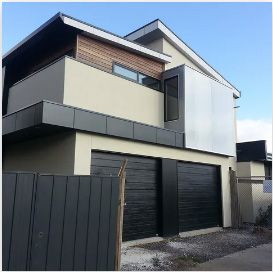 A house with two garage doors and a balcony | Building Services | Coastyle