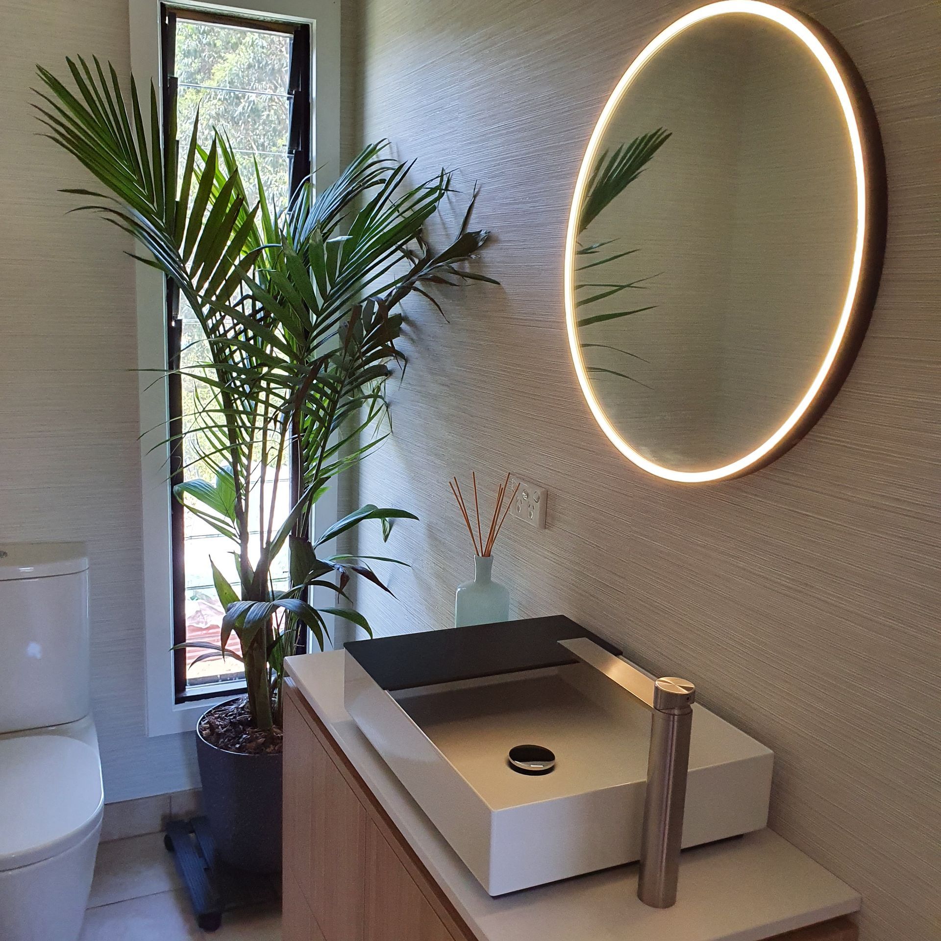 A bathroom with a sink a toilet and a mirror  | Building Services | Coastyle